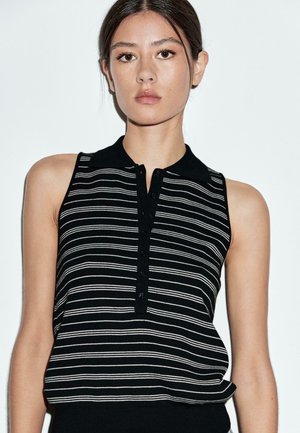 Haut sans manches à rayures noires et blanches avec une patte de boutonnage et un détail de boutons, doté d'un col et d'un tissu doux et texturé.