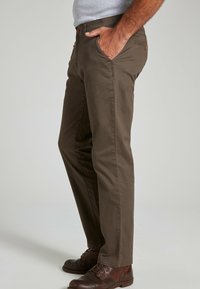 Brown cotton pants with a slim fit, featuring side pockets and back pockets with button accents. Paired with brown lace-up shoes.