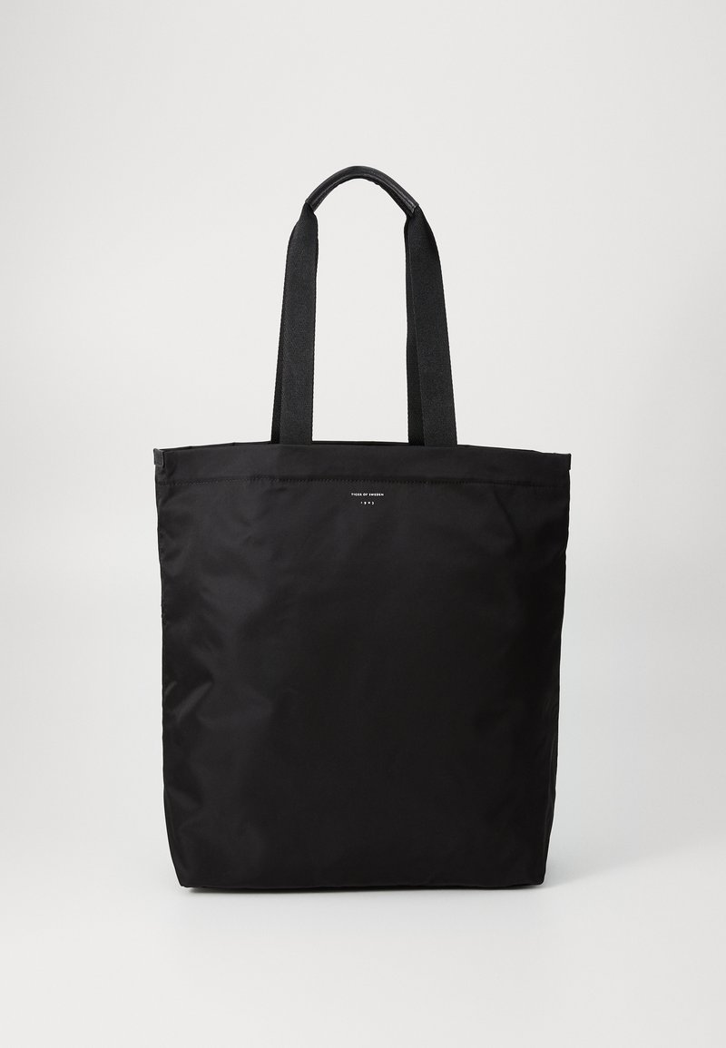Μαύρη τσάντα tote από ανθεκτικό υλικό, με δύο σταθερές λαβές και απλό, χωρίς στολίδια σχέδιο. Ίσια κοπή στην κορυφή και χωρίς ορατά αξεσουάρ.