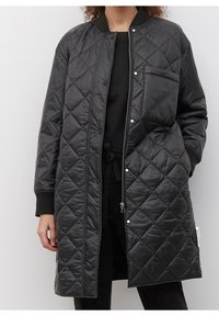 Sort quiltet lang frakke med trykknaplukning, lynlåsåbning foran, sidelommer og ribbet kant. Glat, skinnende ydermateriale.