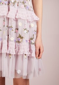 Light pink sheer dress with ruffled lace trim. Features floral embroidery in various colors and layered tulle at the hem.