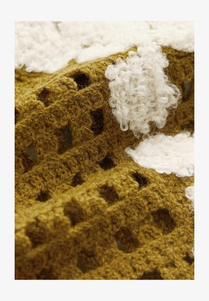 Horgolt textil, amelynek aranysárga alapja van nagy fehér bolyhos elemekkel, nyitott rácsos mintát mutatva és puha textúrával rendelkezik.