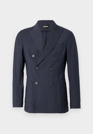 Blazer azul-marinho de abotoamento duplo feito de tecido liso. Apresenta lapelas entalhadas, dois bolsos frontais e seis botões pretos para fechar.
