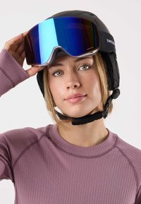 Czarny kask narciarski z regulowanym paskiem pod brodą i osłonami na uszy; lustrzane gogle z niebieskim odcieniem; modelka w fioletowej, prążkowanej bluzce.