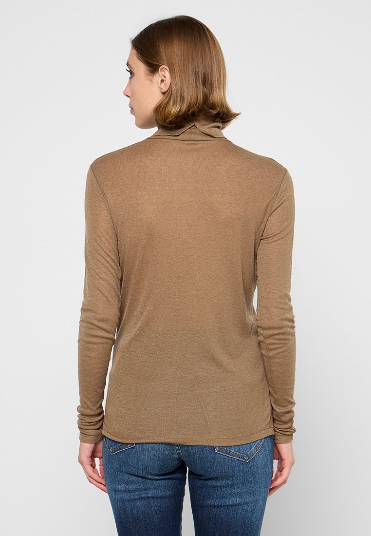 Maglione a maniche lunghe marrone con collo alto, realizzato in morbido tessuto a costine. Design aderente con collo leggermente alto e maniche slim, abbinato a jeans blu.