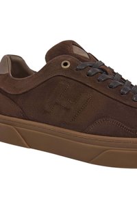 Zapatillas de ante marrón con un acabado texturizado, que presentan una suela ligeramente elevada, cordones grises y un sutil logotipo "H" en relieve en el lateral.