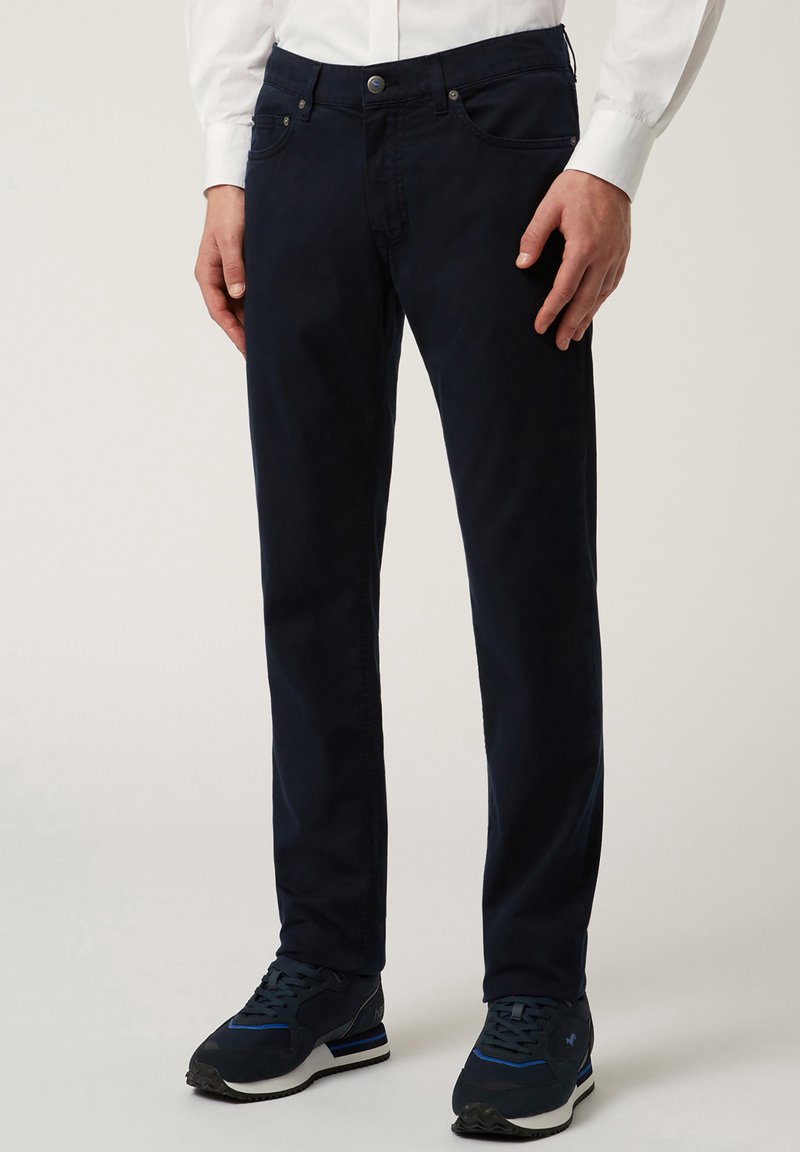 Pantaloni blu navy in cotone. Design dritto con due tasche frontali, una tasca per le monete e una tasca sul retro. Completati con un bottone di chiusura.