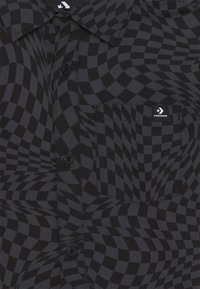 Černá kostičkovaná košile s vířivým vzorem, zapínáním na knoflíky, límcem a náprsní kapsou s bílým logem na hrudi.