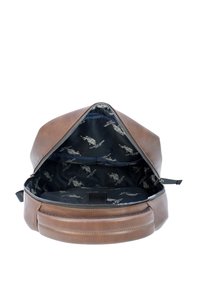 Zaino in pelle marrone con chiusura a zip, dotato di un interno nero a motivi e una piccola tasca per l'organizzazione. Texture liscia e forma arrotondata.