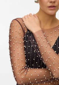 Black dress featuring sheer, embellished sleeves with pearl and rhinestone detailing, showcasing a form-fitting design and smooth texture.