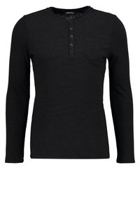 Camisa henley negra de manga larga hecha de tela texturizada con cuello redondo, tapeta de tres botones y un pequeño bolsillo en el pecho.