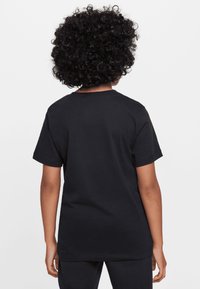 Fekete, rövid ujjú póló, pamutból készült, kerek nyakkivágással és laza fazonnal, sima textúrájáról és klasszikus dizájnjáról ismert.