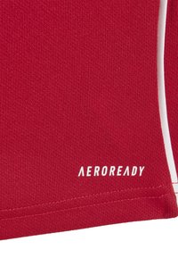 Röd sporttröja i textilerad fabrik. Har vita detaljer och 'AEROREADY'-logotypen i vitt vid nederkanten.