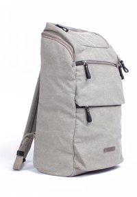 Zaino in tessuto grigio con un design strutturato, multiple tasche con zip e dettagli in hardware nero. Sono visibili le spalline imbottite.