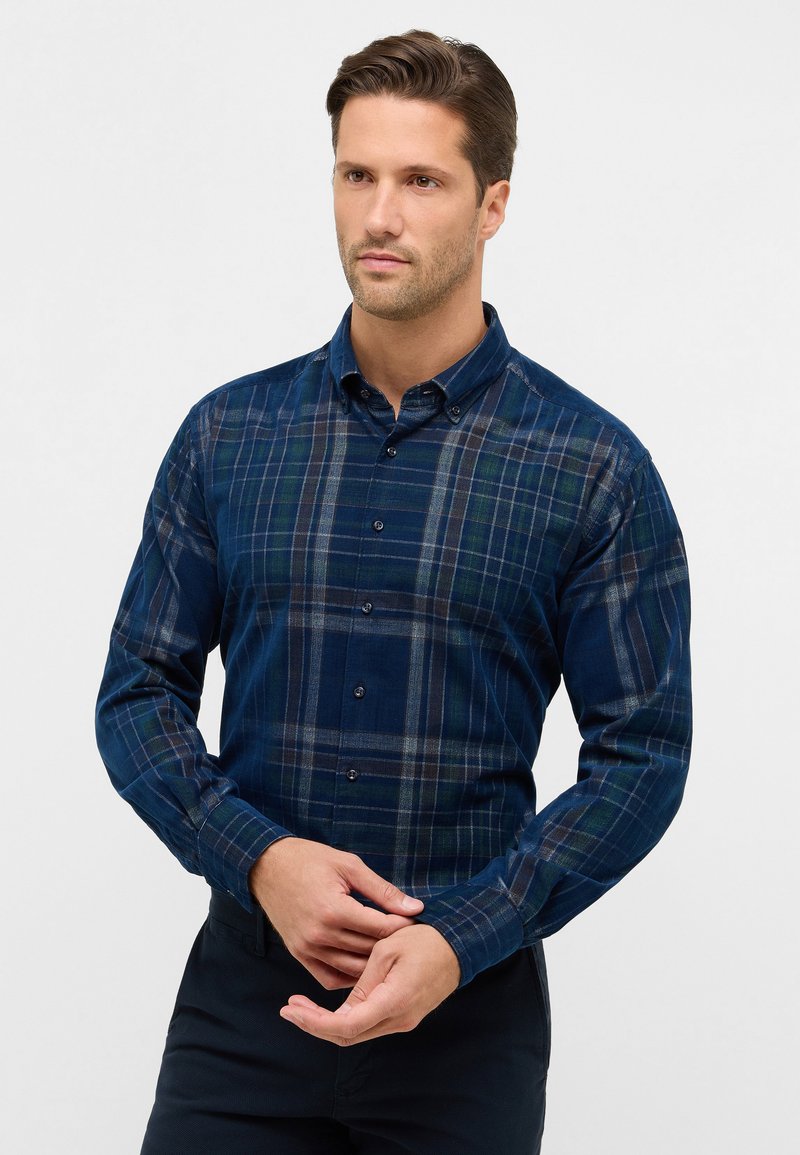 Camicia a quadri blu navy con bottoni, caratterizzata da una consistenza morbida, maniche lunghe e un colletto classico con diversi bottoni sul davanti.