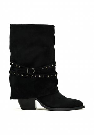 Bottines en daim noir à la coupe décontractée, ornées d'une sangle en stud et d'un petit talon bloc. Texture lisse et bout pointu.