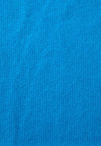 Élénk kék kötött textil, textúrált felülettel, finom, egységes öltésekkel és egyöntetű színnel.