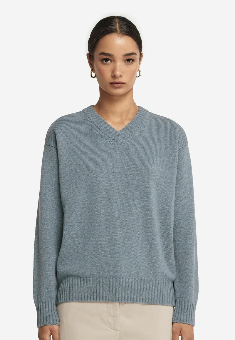 Hellblaues, weiches Strickpullover mit V-Ausschnitt, geripptem Saum und langen Ärmeln. Bietet eine lockere Passform und eine subtile Textur.