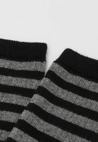 Strikkede sokker med et stribet mønster i sort og grå, med en tekstureret overflade og en ribbede kant for ekstra komfort.
