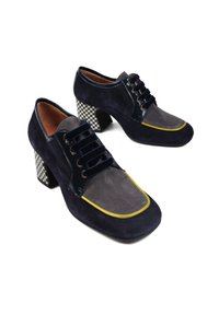 Granatowe i szare zamszowe buty z żółtymi akcentami, z blokowym obcasem w wzór houndstooth i czarnymi sznurowadłami.