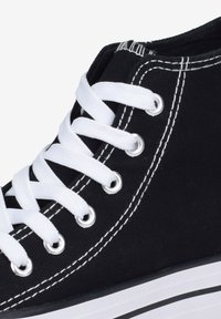 Sneaker high-top in tela nera con occhielli e stringhe bianche. Caratterizzato da cuciture bianche e suola in gomma bianca con strisce nere.