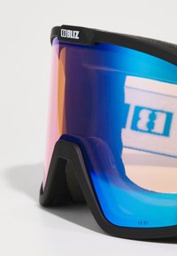 Ski goggles with a black frame, mirrored gradient lens featuring blue, purple, and orange hues, and soft foam padding on the inside.