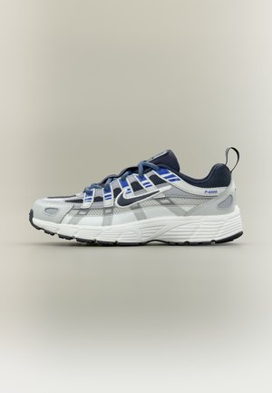 Pantof alergare alb și bleumarin cu accente albastre, partea superioară din plasă, logo Swoosh negru, talpă albă groasă și buclă pentru tragere la călcâi, model P-6000.