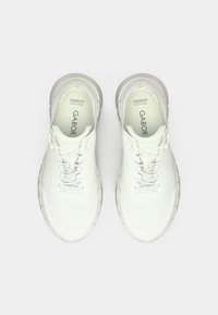 Λευκά αθλητικά παπούτσια με υφασμάτινο επάνω μέρος με υφή, γκρι ανοιχτό χρώμα λεπτομέρειες, παχιά λαστιχένια σόλα και σχεδιασμό με κορδόνια. Διαθέτουν τεχνολογία Flexflex.