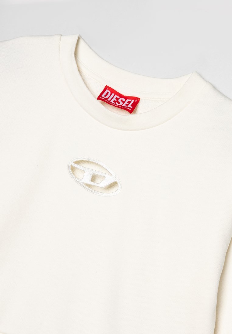 T-shirt bianco in cotone con scollatura rotonda e un piccolo logo ovale ricamato sul petto. Presenta un'etichetta del marchio rossa brillante all'interno del colletto.