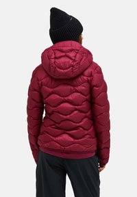 Maroon puffy jacket with a hood, featuring a wavy quilted design and a smooth texture, paired with a black knitted beanie.