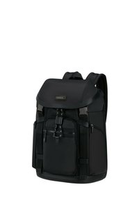 Sac à dos noir en tissu durable avec un rabat de fermeture, une poche avant zippée et des bretelles rembourrées ajustables.