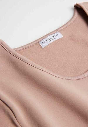 Top sin mangas de color rosa claro con escote redondeado, fabricado en una tela suave. La etiqueta dice “YSABEL MORA PARA MUJERES.” Detalles de costura mínimos.