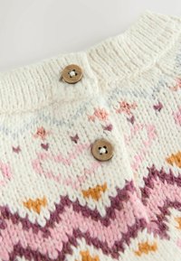 Cremefarvet strikket sweater med pink, lilla og guld mønstre; har to brune knapper ved kraven og struktureret stiksyning.