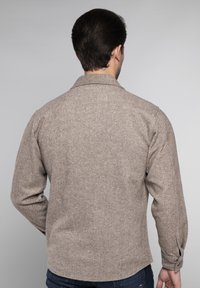 Bruine herringbone-patroon blouse met lange mouwen, knoopmanchetten en een klassieke kraag. Textiel met een gemiddelde gewicht en een gestructureerde stof.