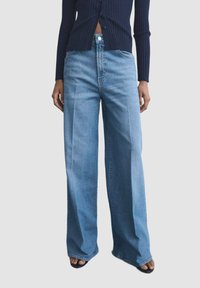 Lyseblå brede jeans lavet af denim, med høj talje, frontlommer og minimale syningsdetaljer.