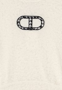 Kremfarget fleece sweatshirt med teksturert finish og svart brodert logo i midten. Designet har rund hals og mansjetterte ermer.