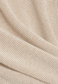 Kermanvärinen teksturoitu kangas, jossa on uritettu kuvio, esittelee pehmeän kudotun ilmeen ja ristikkäisviimeistelyn.