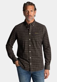 Heren overhemd met lange mouwen in donkergekleurde tartan, voorzien van een button-down kraag, een voorzak en witte knopen. Zachte stof met een structuurafwerking.