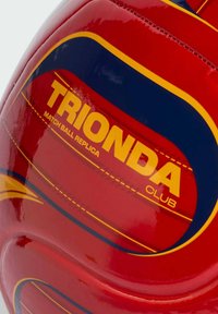 Replika lopte za utakmice TRIONDA Kluba u crvenoj i žutoj boji s plavim i žutim zakrivljenim prugama i šivenim panelima.