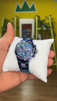 Orologio cronografo con cinturino metallico blu, arricchito da dettagli scintillanti. Presenta un quadrante blu brillante e tre sottoquadranti.