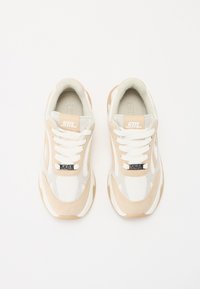Sneakers beige e bianchi realizzati in mesh e suede. Punta rotonda, lacci piatti, collare imbottito e linguetta con logo.