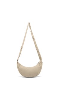 Sac bandoulière beige en forme de croissant avec une sangle réglable et des détails subtils de fermeture éclair.