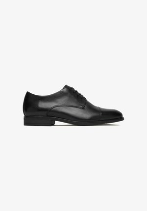 Schwarzer Oxford-Schuh aus poliertem Leder mit geschlossener Schnürung, niedrigem Absatz und Kappzehe, von der Außenseite auf weißem Hintergrund dargestellt.