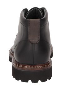 Bottine en cuir noir avec une finition lisse, un contrefort de talon marron contrastant, une semelle robuste et des coutures détaillées le long du bord.