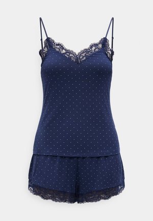Marineblaues Camisole- und Shorts-Set mit weißen Punkten und Spitzenbesatz am Ausschnitt und an den Saumabschlüssen der Shorts.