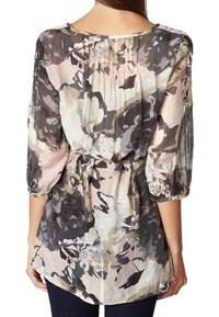 Blusa leggera con un motivo floreale in toni tenui di rosa, grigio e beige, con maniche a trequarti e vita con cintura.