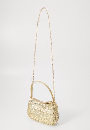 Goldene Abendhandtasche mit Pailletten, kurzem Ledergriff und langem dünnem goldenen Kettenriemen auf weißem Hintergrund.