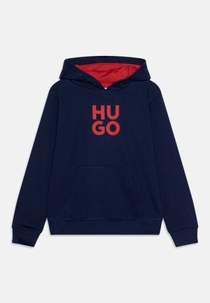 Sweat à capuche bleu marine avec intérieur rouge et un grand logo "HUGO" rouge sur le devant. Doté d'une poche avant et de poignets côtelés.