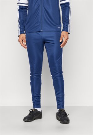 Pantalons de survêtement de sport de marine en tissu lisse, avec des rayures blanches sur les côtés, une coupe fuselée et un logo discret sur la taille.