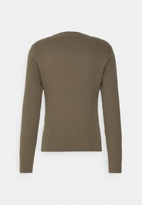 Grüner, gerippter Strickpullover mit langen Ärmeln, rundem Hals und strukturiertem Muster. Verfügt über einen taillierten Bund und Bündchen sowie ein kleines Logo-Tag am Saum.